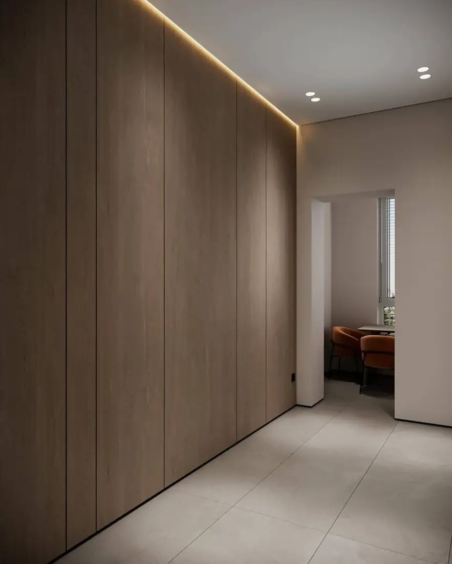 Full-height fitted timber wardrobe wall with concealed cove lighting
